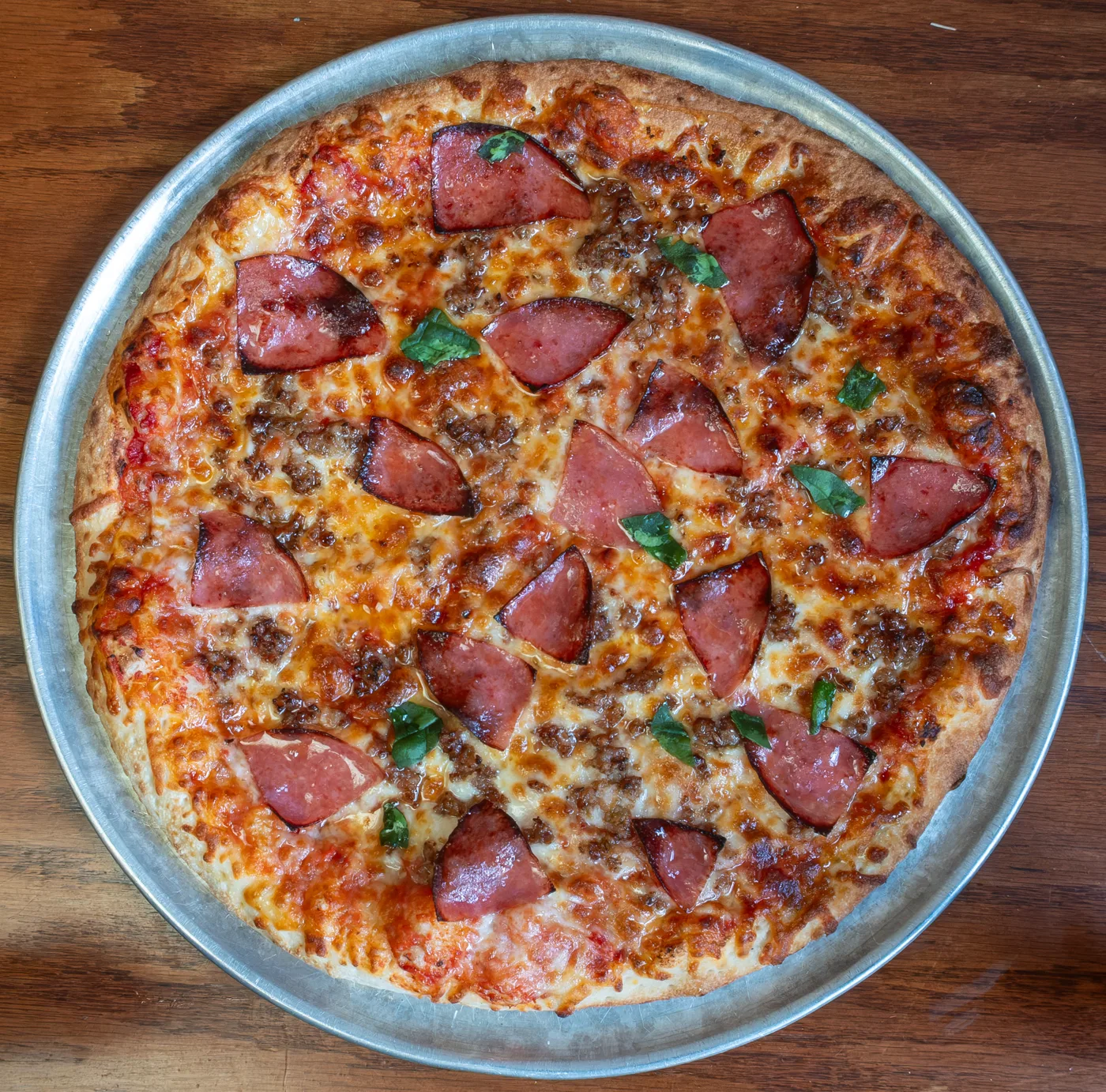 Apollo's Hot Sweet Italian pizza with sausage, salami, basil, and melted cheese.
