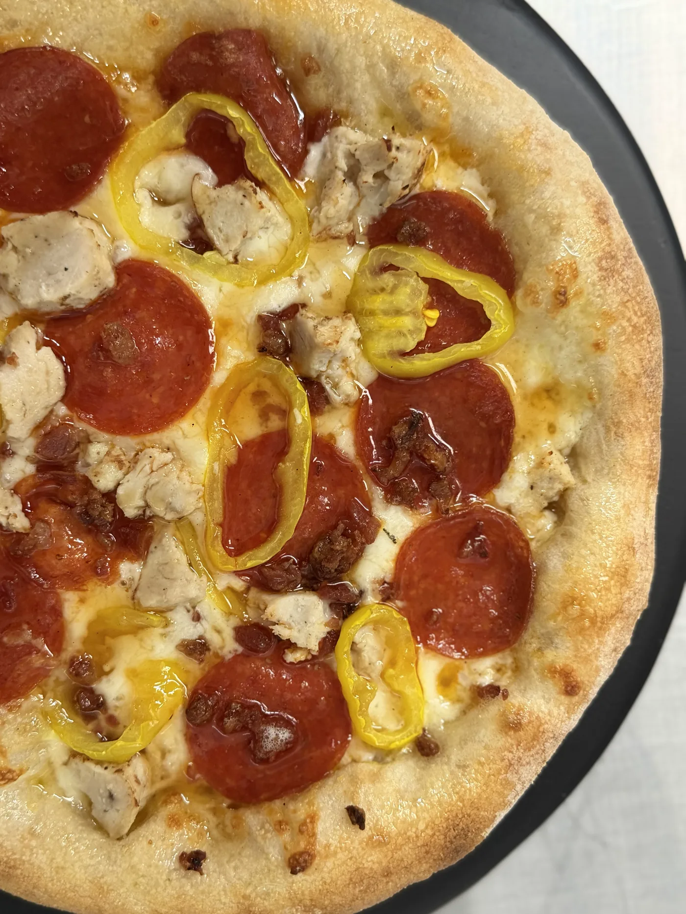 Frenchy's Big Homie pizza with chicken, bacon, pepperoni, banana peppers, and hot honey.