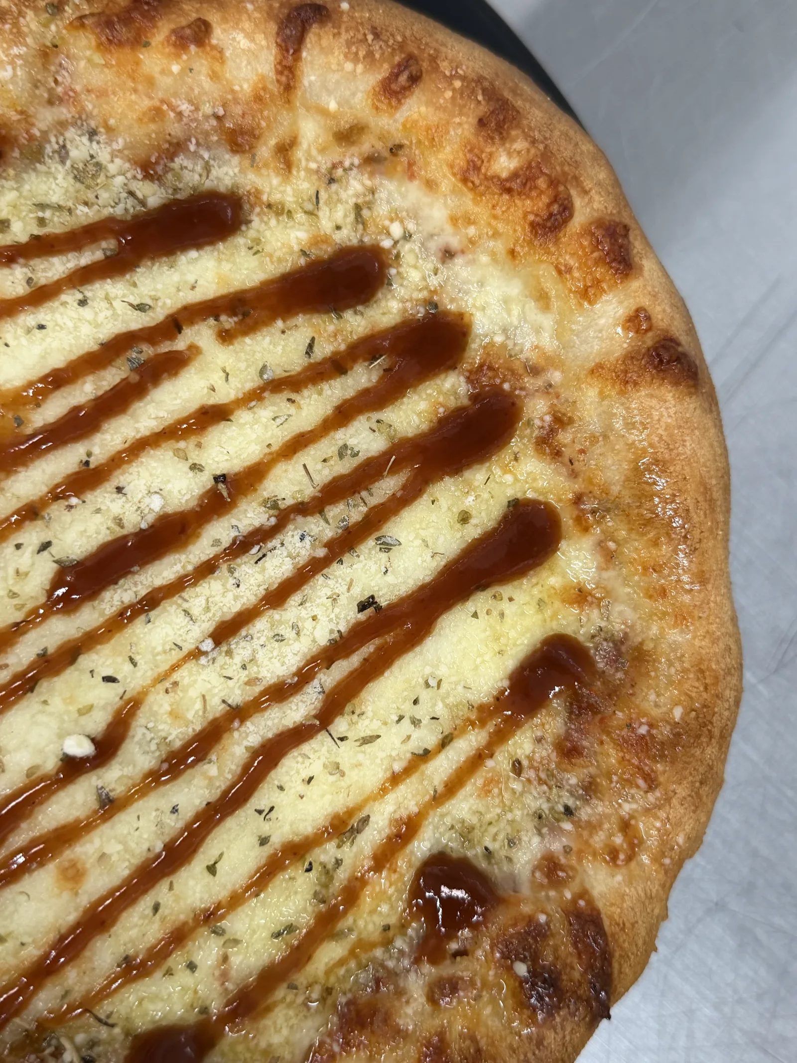 Frenchy's Long Story Short cheese pizza with smoky barbecue hot honey drizzle.