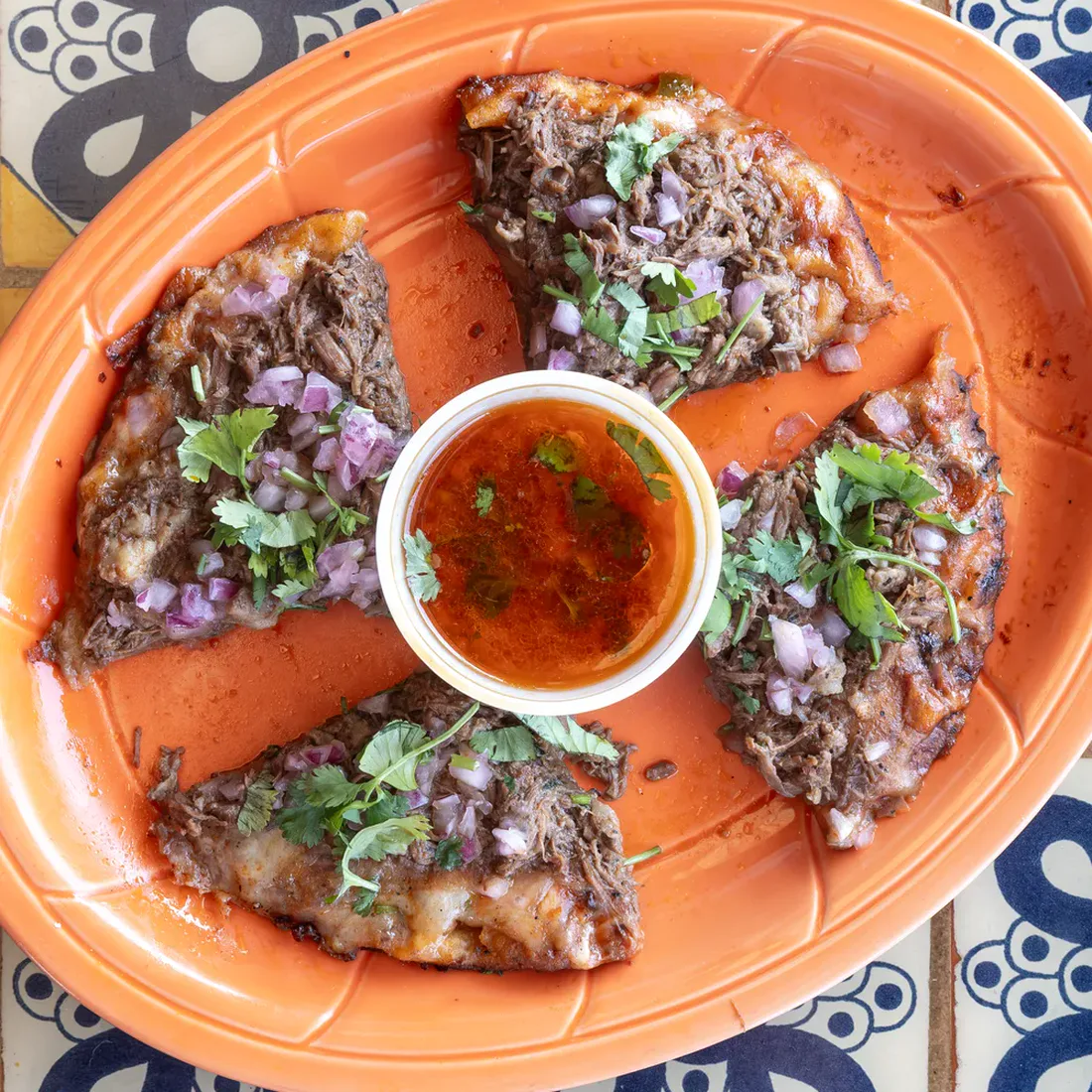 Mi Pequeña Hacienda's Barbacoa Birria Pizza with shredded beef, onion, cilantro, and queso.