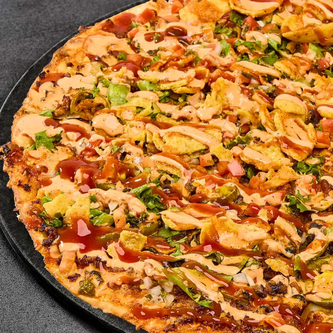 Parlour Pizza's Outlaw pizza with taco meat, black beans, jalapeños, lettuce, Fritos, and southwest ranch.