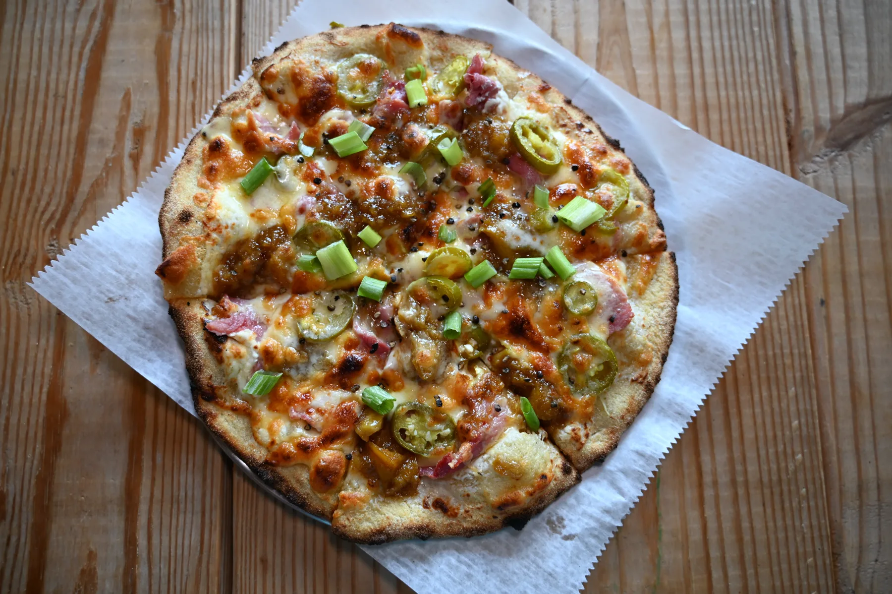 Rolling Oven's Southern Fried Green pizza with roasted green tomatoes, caramelized onion, pickled red onion, and green onion.