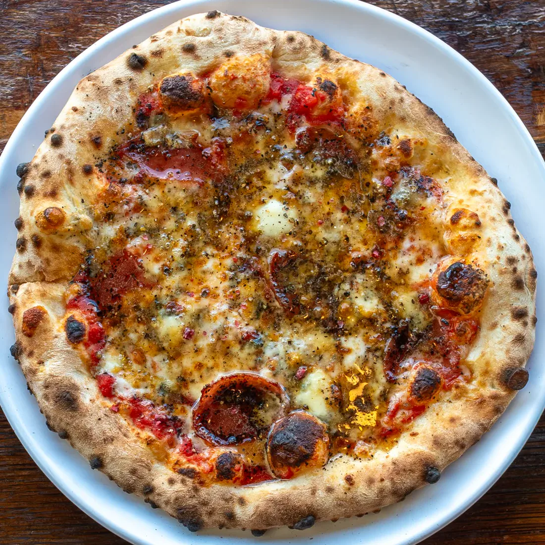 Smashing Tomato's Firecracker pizza with salami, Gorgonzola, chili crunch, pink peppercorns, and hot honey.