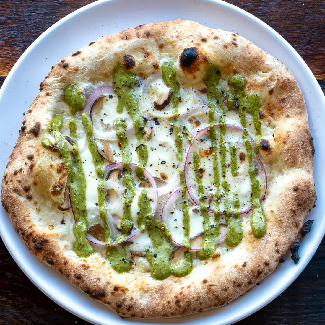 Smashing Tomato's Funghi di Bufala pizza with Bufala mozzarella, shiitake mushrooms, onions, rosemary chimichurri, and black pepper.