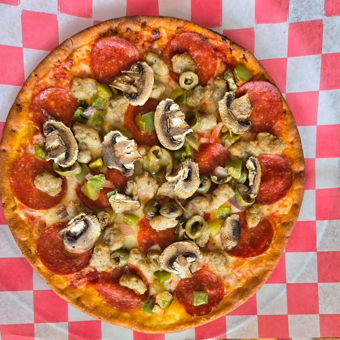 Southland Lanes' Dude's Meaty Abide supreme pizza with pepperoni, sausage, peppers, olives, onions, and mushrooms.